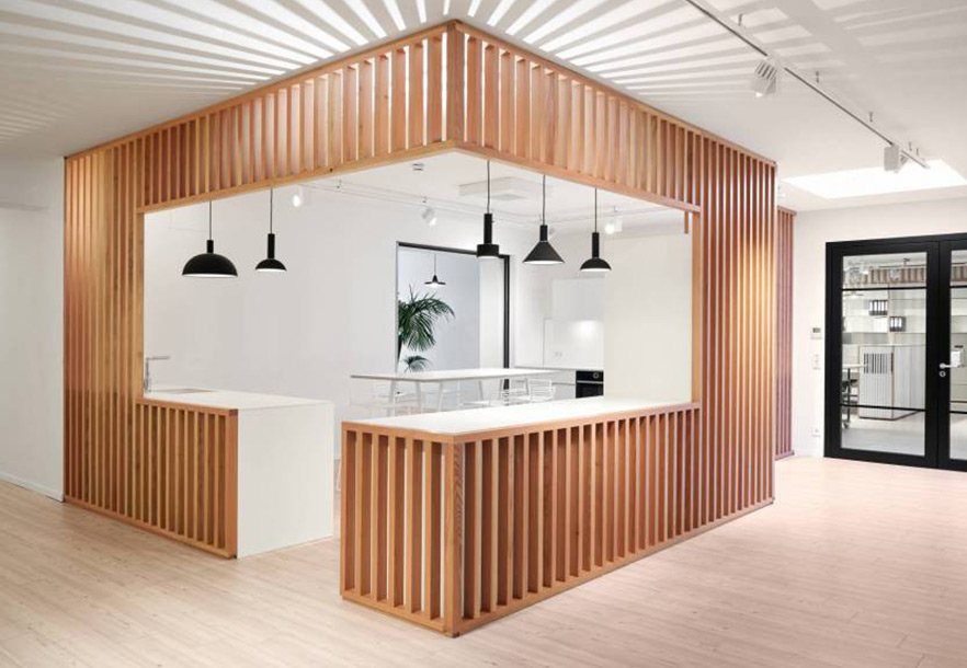 Kücheninsel im Büro von Maryan Beachwear von Schemberg Ladenbau Offene Kücheninsel mit hellen Holzlamellen im Büro von Maryan Beachwear von Schemberg Ladenbau