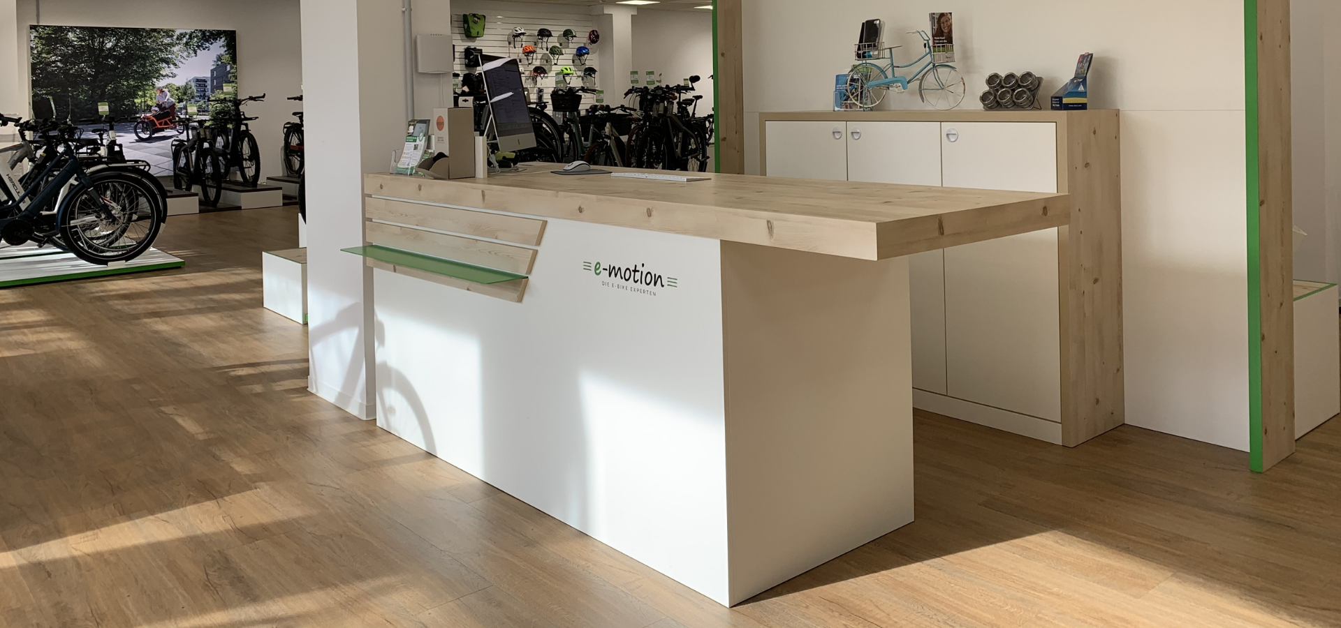 Neuer Verkaufsraum für e-Motion in Hannover mit Fahrradpodesten und großem Verkaufstresen realisiert von Schemberg Ladenbau