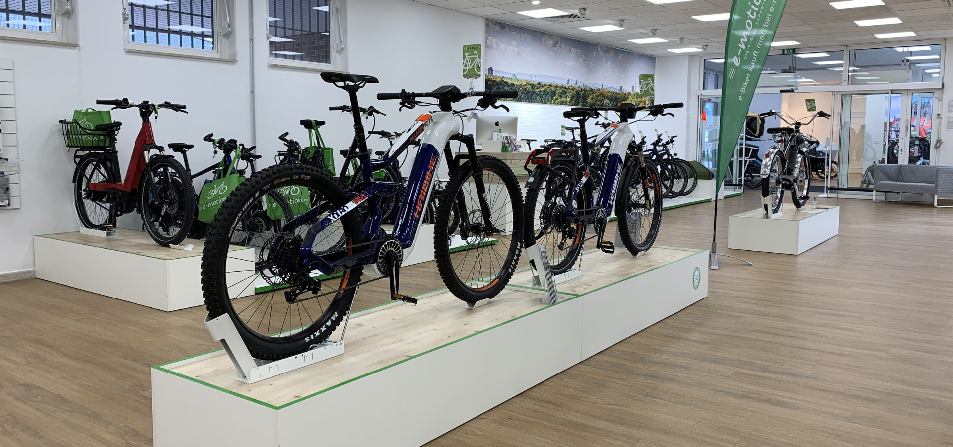Neuer Verkaufsraum für e-Motion in Hannover mit Fahrradpodesten und großen Imagebildern realisiert von Schemberg Ladenbau